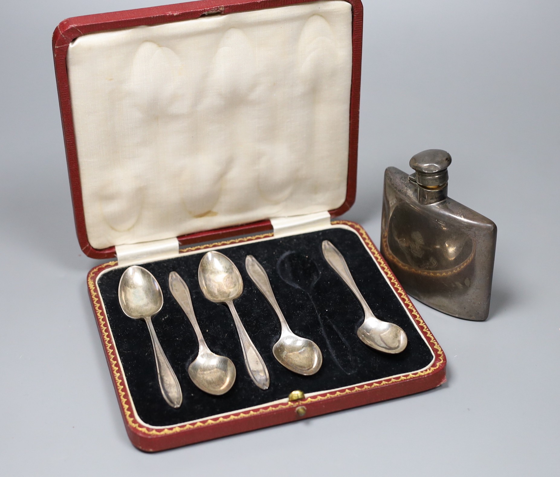 A Victorian silver hip flask with lockable cap, engraved Hogg family crest, London 1894, together with a cased part-set of five silver coffee spoons, Sheffield. 1923